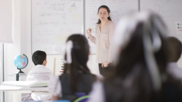 Crianças em sala de aula ouvindo professor — Vídeo de Stock