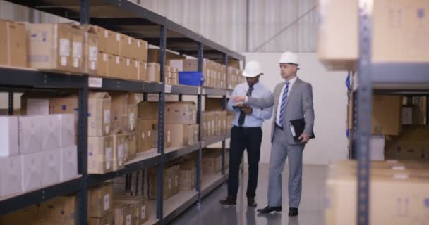 Usinessmen in discussion walk through warehouse — Stock Video