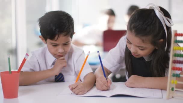 Niño y niña trabajando en sus escritorios — Vídeos de Stock