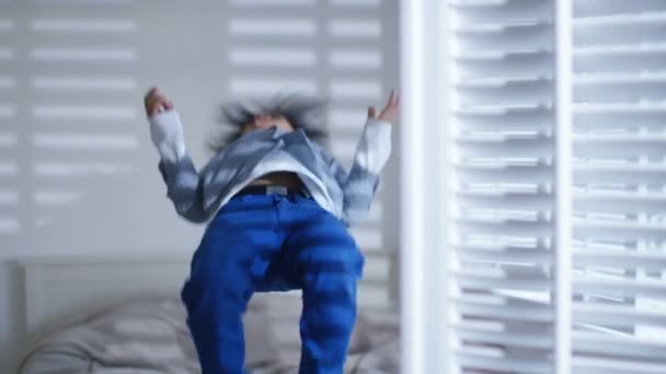 Junge springt auf das Bett — Stockvideo