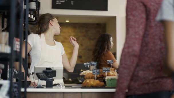 Werknemer in dienst van een klant in de winkel — Stockvideo