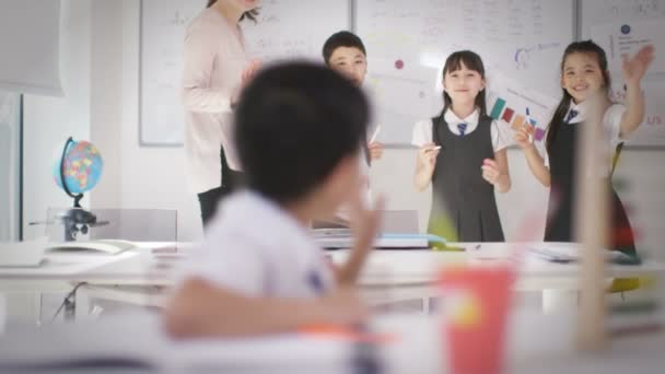 Niño pequeño en su escritorio en el aula — Vídeos de Stock