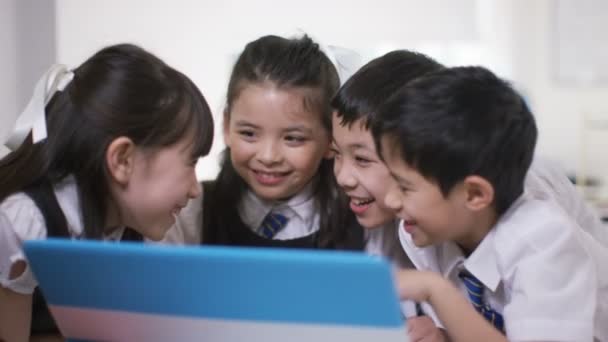 Children looking at computer in school classroom — Stock Video