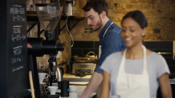 Sonriente trabajador de pie detrás de contador — Vídeos de Stock