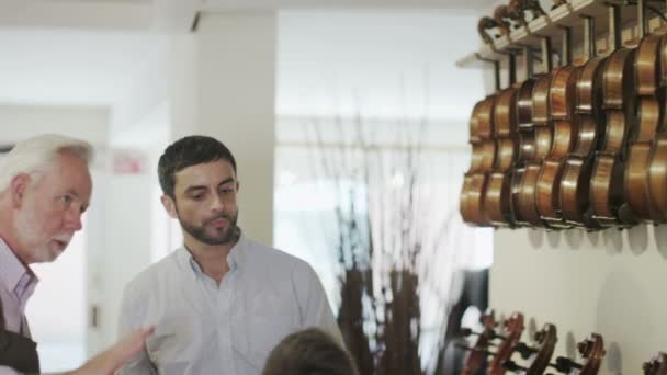 Father and son  looking at violins — Stock Video