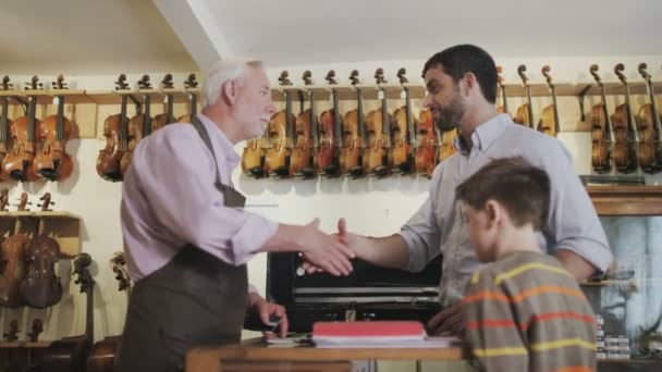 Father and son  looking at violins — Stock Video