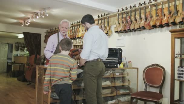 Отец и сын смотрят на скрипки — стоковое видео