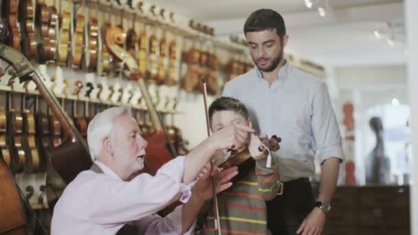 Father and son  looking at violins — Stock Video