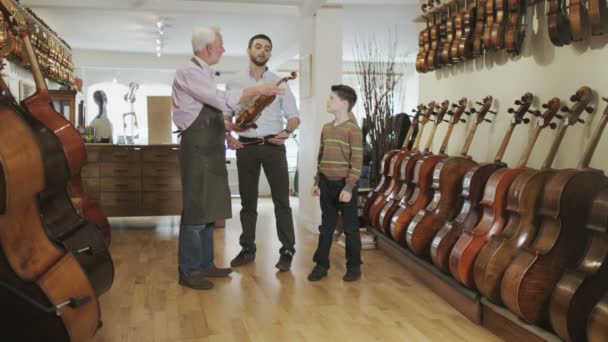 Father and son  looking at violins — Stock Video