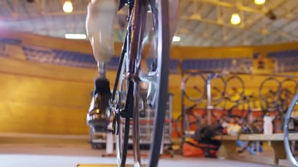 Ciclista practicando con entrenador en velódromo — Vídeo de stock