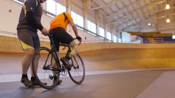 Cyklista cvičit s trenérem v velodrome — Stock video