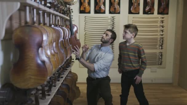 Pai e filho comprando em uma loja musical — Vídeo de Stock