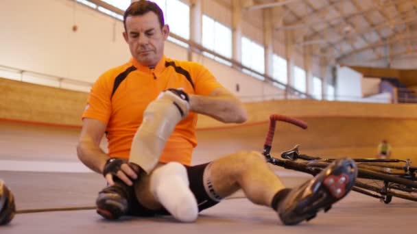 Человек с протезной ногой на велотреке — стоковое видео