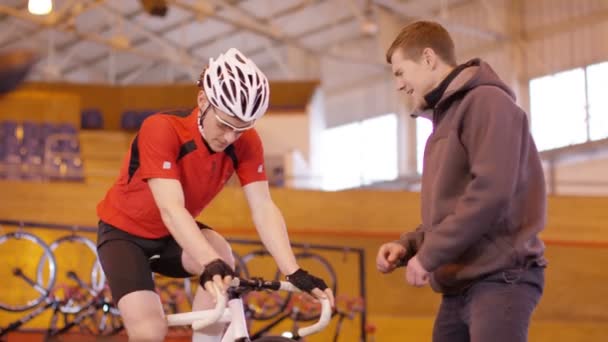 Fietser met coach training over statische fiets — Stockvideo