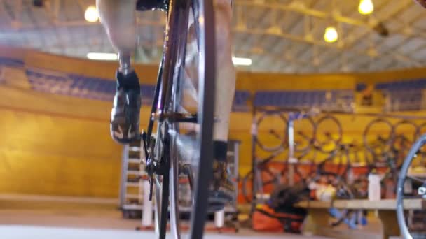 Ciclista practicando con entrenador en velódromo — Vídeo de stock