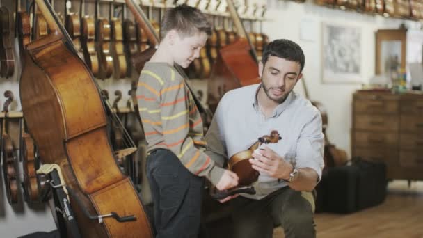 Apa és fia egy zenei áruházban vásárlás — Stock videók