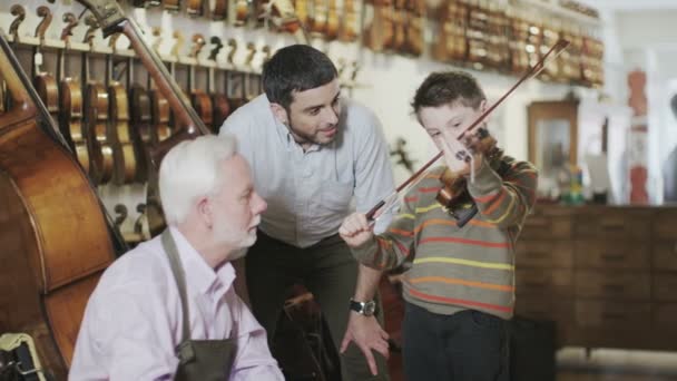 Père et fils regardant des violons — Video