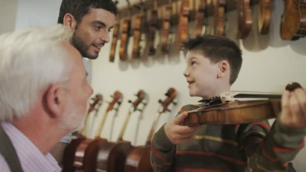 Father and son  looking at violins — Stock Video