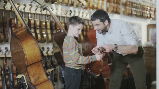 Vader en zoon winkelen in een muzikale winkel — Stockvideo