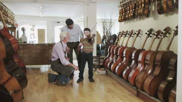 Father and son  looking at violins — Stock Video