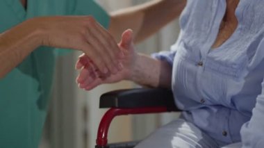 Yaşlı hasta elini tutarak hemşire