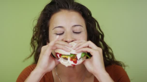 Vrouw die een hamburger eet — Stockvideo