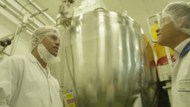 İşçiler fabrikada makine kontrol