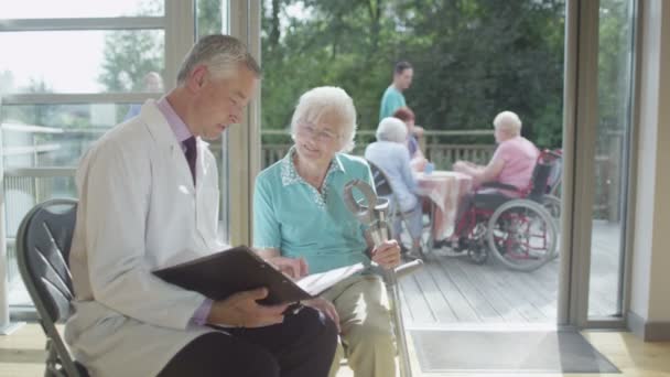 Doctor discutiendo notas médicas con el paciente — Vídeo de stock