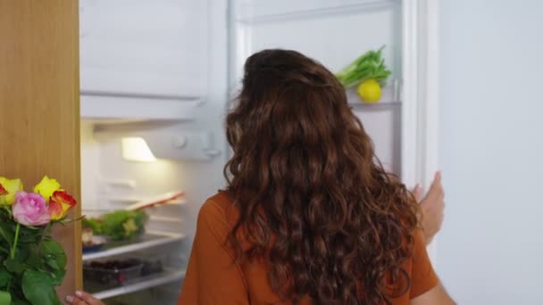 Женщина идет к холодильнику перекусить — стоковое видео