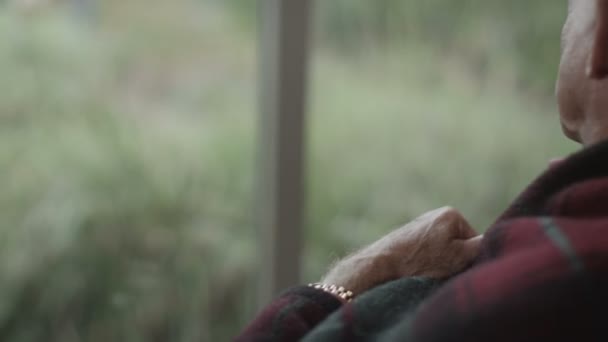 Hombre mayor sentado junto a la ventana — Vídeo de stock