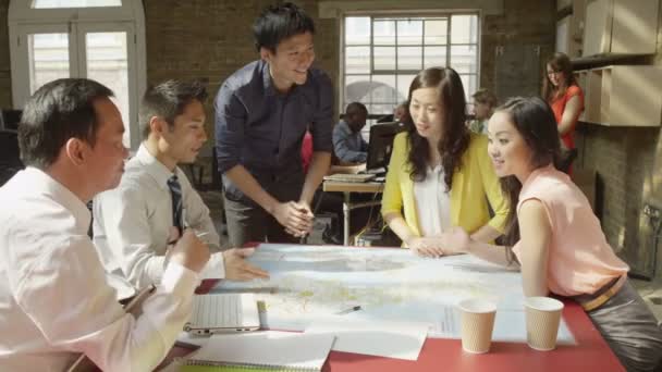 Business-team tittar på en karta — Stockvideo