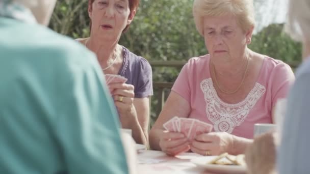 Старші друзі грають у карти — стокове відео