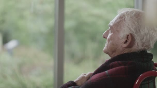 Senior férfi ült az ablaknál — Stock videók
