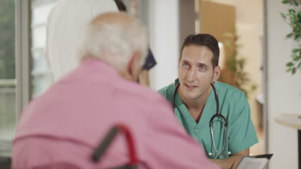 Врач обсуждает медицинские записи с пациентом — стоковое видео