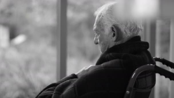 Starszy mężczyzna siedzący przy oknie — Wideo stockowe