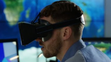 4k işadamı, fütüristik office sanal gerçeklik kulaklık ile etkileşim gösteren finansal bilgi ve Dünya Haritası bilgisayar ekranları