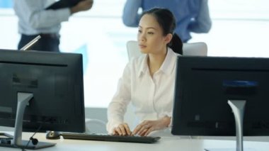 4k portre gülümseyen işkadını masasında arka planda meslektaşları ile çalışma