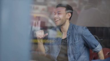 4K Arkadaşlar bir kafede dinleniyor, cam pencereden çekiliyor.