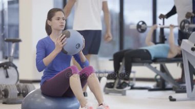 Spor salonunda sağlık topu ile çalışma dışarı çekici gülümseyen kadın portresi