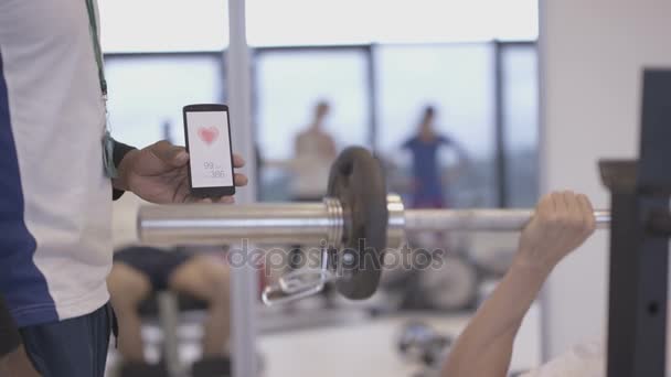 Trener Fitness Pomocą Aplikacji Smartphone Pociągu Klientem Siłowni — Wideo stockowe
