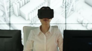 4k giyen sanal gerçeklik Görüntüleyici arka planda mimari yapısının animasyonlu grafik ile onun masasında mühendisi