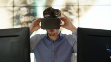 arka planda bir veri tünel animasyonlu grafik ile onun masasında bir sanal gerçeklik Görüntüleyici giyen 4 k heyecanlı mühendis veya bilgisayar programcısı