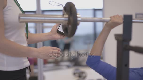 Trener Fitness Pomocą Aplikacji Smartphone Pociągu Klientem Siłowni — Wideo stockowe