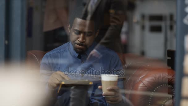 Pensive 젊은이 카페에 컴퓨터 태블릿을 있습니다 — 비디오