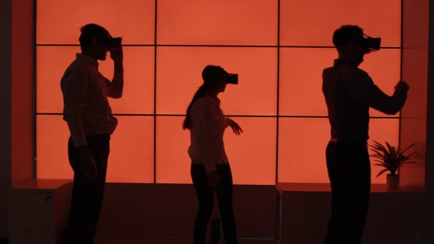 业务团队在剪影尝试虚拟现实观众在红色背景 — 图库视频影像