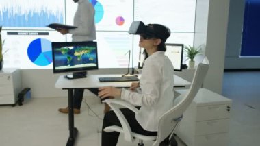 4k işkadını, fütüristik office sanal gerçeklik kulaklık ile etkileşim gösteren finansal bilgi ve Dünya Haritası bilgisayar ekranları