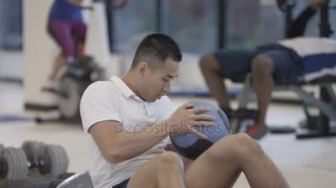 Spor salonunda sağlık topu ile çalışma dışarı çekici sağlıklı adam