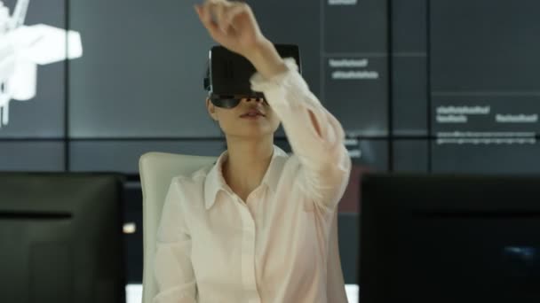 工程师穿着虚拟现实查看器在她的办公桌与动画图形的背景建筑结构 — 图库视频影像