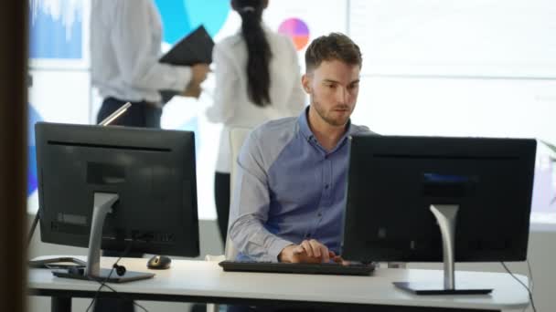 Young Businessman Working Computer His Desk Colleagues Looking Video Wall — Stock Video