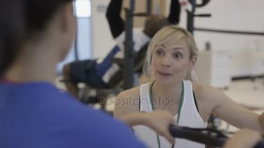 Modern spor salonunda tren için müşterilerine yardımcı antrenör gülümseyen